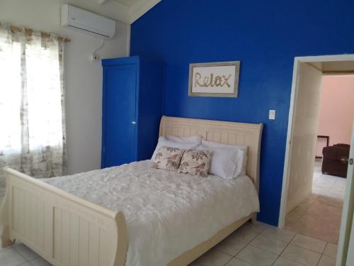 una camera da letto con pareti blu e un letto con cuscini di 1 Queen Bedroom At Csompó Empire a St Mary