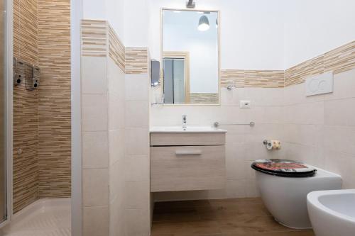 a bathroom with a sink and a toilet and a mirror at Le Ghiande Guest House in Casal Palocco