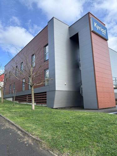 a building with a sign on the side of it at Kyriad Le Mans Est in Le Mans