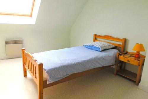 - une chambre avec un lit en bois et une table de chevet dans l'établissement Maison avec jardin à 400m de la plage à Landrellec en PLEUMEUR-BODOU Ref 250, à Pleumeur-Bodou