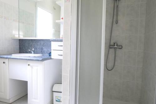 une salle de bain avec un lavabo et une douche dans l'établissement Maison avec jardin à 400m de la plage à Landrellec en PLEUMEUR-BODOU Ref 250, à Pleumeur-Bodou