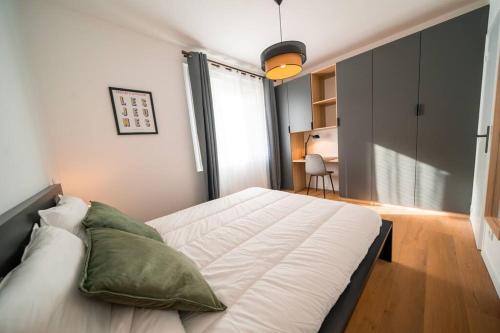 une chambre avec un grand lit blanc dans une pièce dans l'établissement L'Hédoniste, Elégant T2, Clim, Centre Ville, à Montpellier