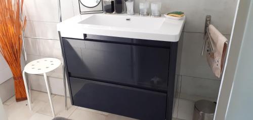 La salle de bains est pourvue d'un lavabo et d'un comptoir blanc. dans l'établissement Appartement léonard, à Châtelaillon-Plage