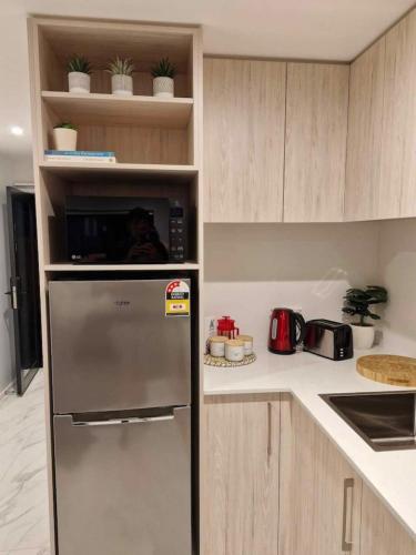 a kitchen with a stainless steel refrigerator with a microwave at Cosy CBD Studio Apartment 6 in Christchurch