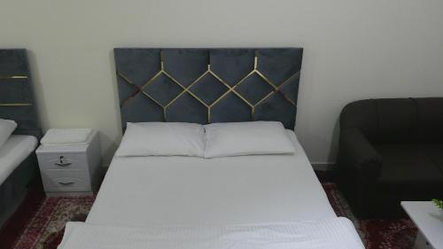 a bedroom with a bed with a black headboard at Ruby Star Hostel Dubai F2 in Dubai