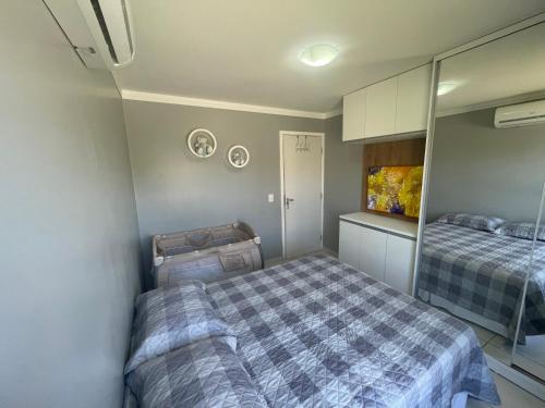 ein kleines Schlafzimmer mit 2 Betten und einem Spiegel in der Unterkunft Casa em Condomínio Fechado na Praia do Francês in Marechal Deodoro