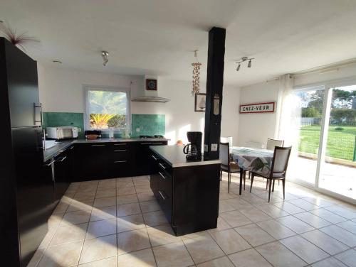 une cuisine avec une table et une salle à manger dans l'établissement Maison à 200m de la plage avec jardin clos sur l'ILE GRANDE - Réf 283, à Pleumeur-Bodou