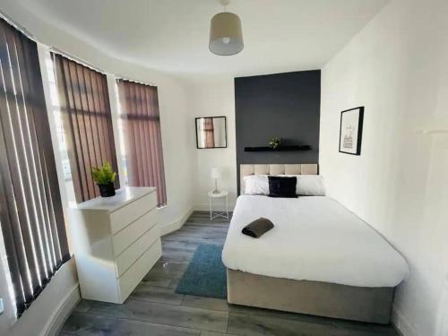 a bedroom with a large white bed and windows at Suite 1 - Large Private Room near City Centre in Liverpool