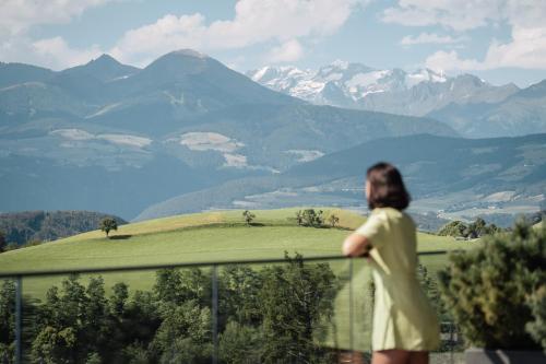 a woman standing on a balcony looking at the mountains at Santre dolomythic home in Bressanone