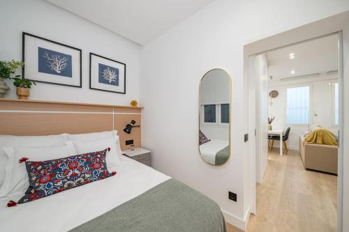 Schlafzimmer mit einem Bett und einem Spiegel in der Unterkunft Luxury flat Mayor II in Madrid