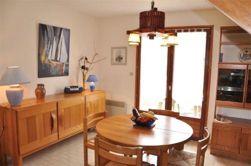 une cuisine avec une table et une salle à manger dans l'établissement Maison à 250m de la belle plage de Pors Gelen et de l'école de voile - Réf 293, à Pleumeur-Bodou
