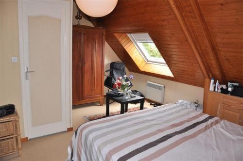 une chambre avec un lit avec une chaise et une fenêtre dans l'établissement Maison à 250m de la belle plage de Pors Gelen et de l'école de voile - Réf 293, à Pleumeur-Bodou