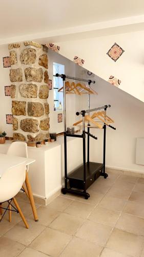 Cette chambre dispose d'une table et d'un mur en pierre. dans l'établissement L’amazone, à Sannois