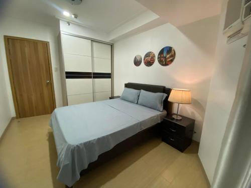 um pequeno quarto com uma cama e um candeeiro em SnugglePod Condotel - Grand Riviera Suites, US Embassy Manila, Roxas Blvd em Manila
