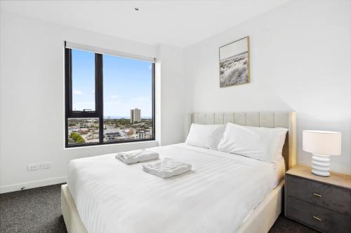 een slaapkamer met een groot wit bed en een raam bij Vibrant Southbank 2 bedroom Apartment in Melbourne