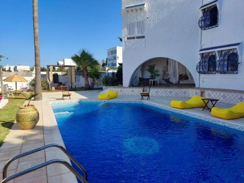 a swimming pool next to a building at Dar Salama in Bizerte