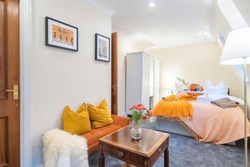 um quarto com uma cama com almofadas amarelas e uma mesa em Livestay-Chic 3-Bed Mews Townhouse in St John's Wood em Londres