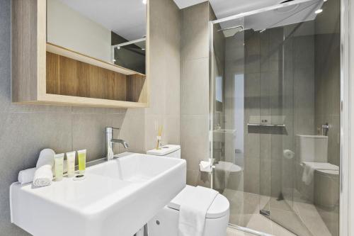 een badkamer met een wastafel, een toilet en een douche bij Vibrant Southbank 2 bedroom Apartment in Melbourne