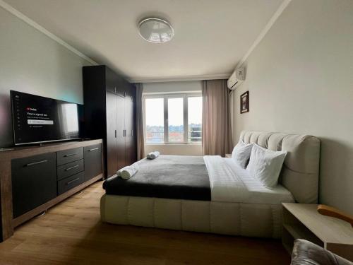 a bedroom with a bed and a flat screen tv at Amazing view central 1 bedroom apartment in Pazardzhik