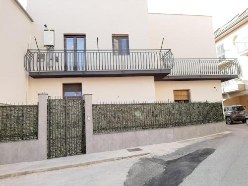 a white building with a fence and a balcony at Villa Giardiso in Valguarnera Caropepe