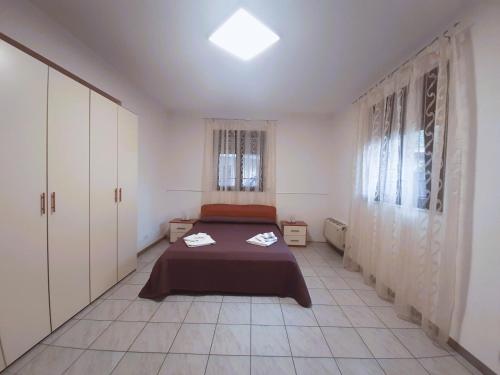 ein Schlafzimmer mit einem Bett in einem Zimmer mit weißen Schränken in der Unterkunft Villa Giardiso in Valguarnera Caropepe