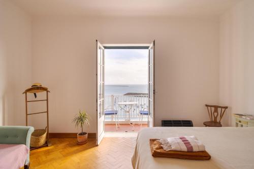 a bedroom with a bed and a door to a balcony at Manas Coliving in Sines