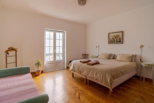 a bedroom with a large bed in a room at Manas Coliving in Sines