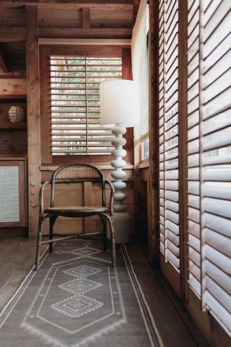 a chair and a lamp in a room with windows at Lovango Resort and Beach Club in Cruz Bay