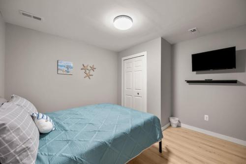 a bedroom with a bed and a flat screen tv at Lakeside Bliss 2BR, 1BA with All Modern Comforts in Algonac