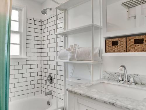 ein weißes Badezimmer mit einer Badewanne und einem Waschbecken in der Unterkunft Hiatus House in Savannah