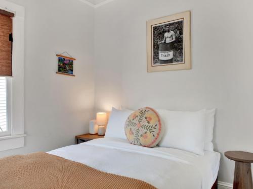 ein Schlafzimmer mit einem weißen Bett und einem Kissen darauf in der Unterkunft Hiatus House in Savannah