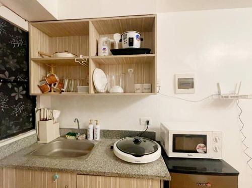 cocina con fregadero y microondas en The Hideaway by K&C 1BR, Netflix,PS4, Wifi, en Imus
