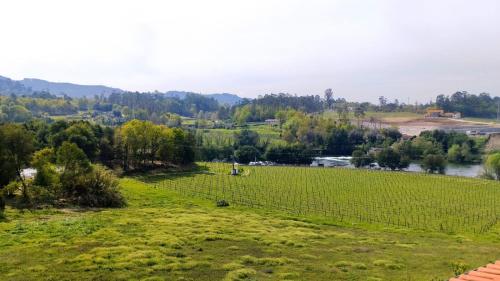 an empty field with a river in the background at Quinta do Burgo - Nature Hotel in Amares