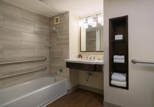 a bathroom with a tub and a sink and a mirror at Atlanta Marriott Perimeter Center in Atlanta