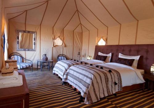 a bedroom with a large bed in a tent at Amazing Luxury Camp in Merzouga