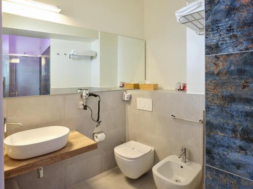 a bathroom with a sink and a toilet and a mirror at UNAWAY Imperial Beach Hotel in Marotta