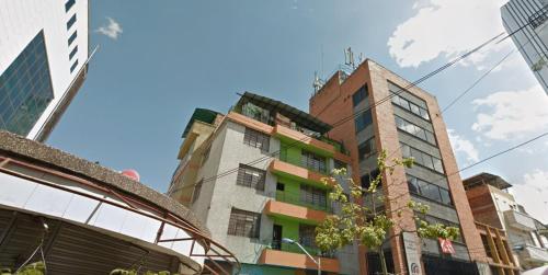 a tall building in the middle of a city at Hotel Estacion San Antonio in Medellín