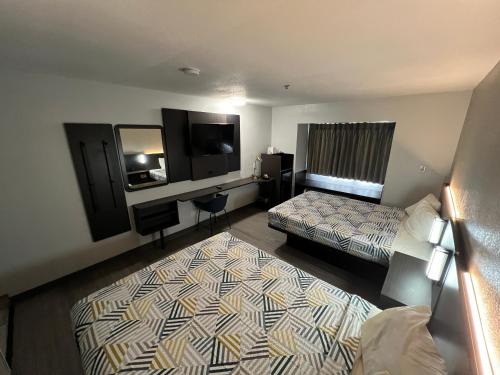a hotel room with two beds and a television at Motel 6-Simpsonville, SC - Greenville in Simpsonville