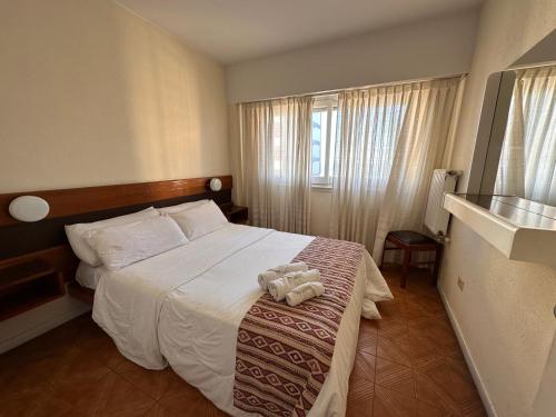 a hotel room with a bed with a stuffed animal on it at Hostal del Sol in San Bernardo