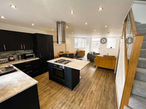 uma cozinha em plano aberto e sala de estar com uma escadaria em Jollys em Sandown