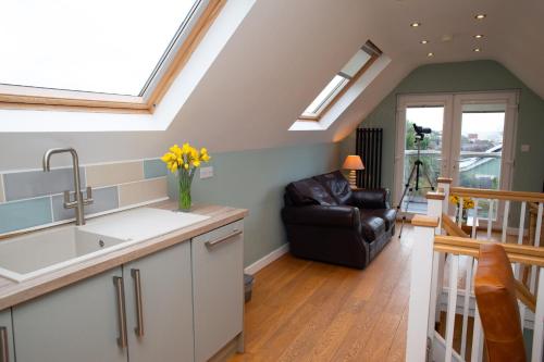 a kitchen and living room with a couch and skylights at Vilureef Broad Haven in Broad Haven