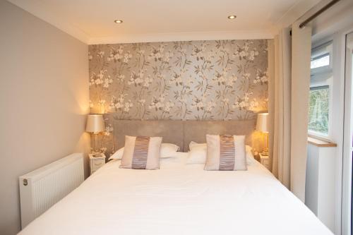 a bedroom with a large white bed with two pillows at Vilureef Broad Haven in Broad Haven