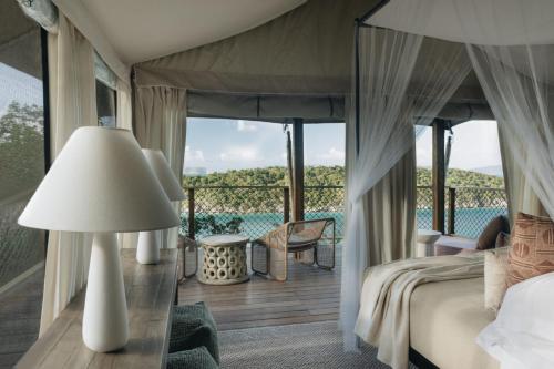 a bedroom with a bed and a balcony with a view at Lovango Resort and Beach Club in Cruz Bay