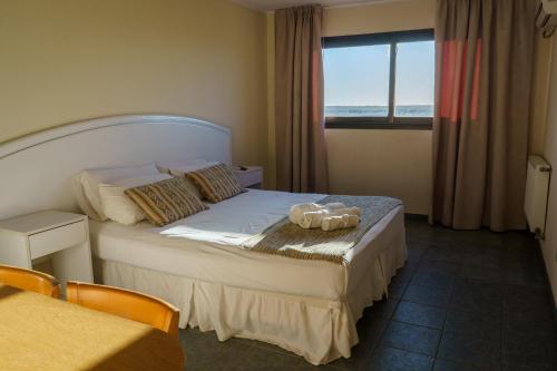 a hotel room with a bed and a window at Hostal del Sol in San Bernardo