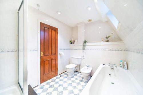 a bathroom with a toilet and a tub and a sink at Livestay-Chic 3-Bed Mews Townhouse in St John's Wood in London