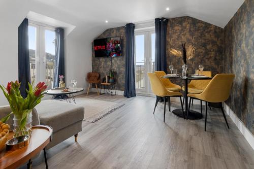a living room with a table and yellow chairs at Sea views, Beachbreeze, Pet friendly, Private parking in Teignmouth