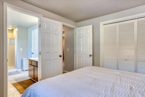 a bedroom with a white bed and a bathroom at Tranquility Base - Family Fun Modern Farm House in Dalton Gardens