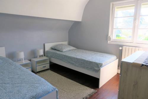 une chambre avec deux lits et une fenêtre dans l'établissement Maison rénovée avec jardin clos et WIFI à PERROS-GUIREC - Réf 335, à Perros-Guirec