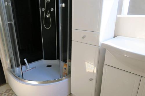 une douche avec une porte vitrée dans une salle de bain dans l'établissement Maison rénovée avec jardin clos et WIFI à PERROS-GUIREC - Réf 335, à Perros-Guirec