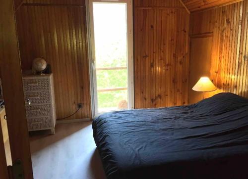 ein Schlafzimmer mit einem Bett und ein Fenster mit einer Lampe in der Unterkunft Chalet de Montagne in Valdeblore
